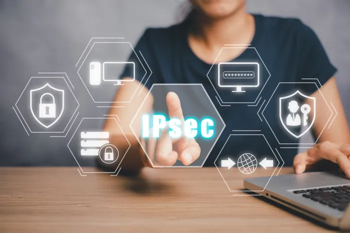 A woman using a laptop on a wooden table touching a holographic image that reads "IPsec"